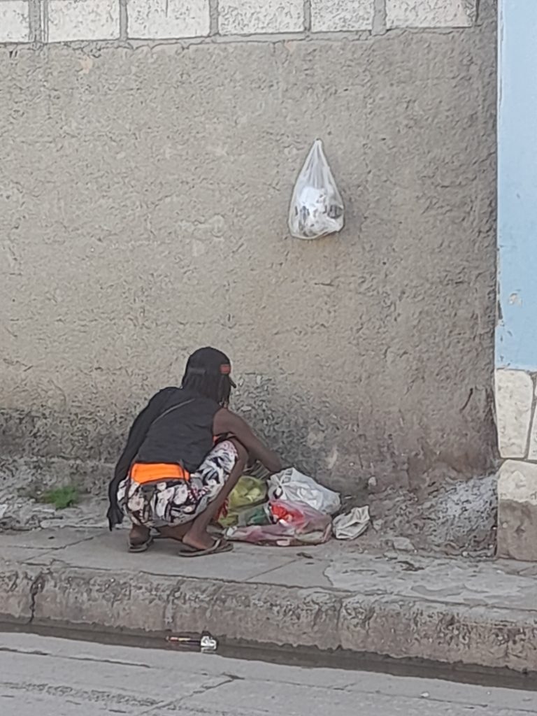 Una anciana revisa en la basura en una calle cubana